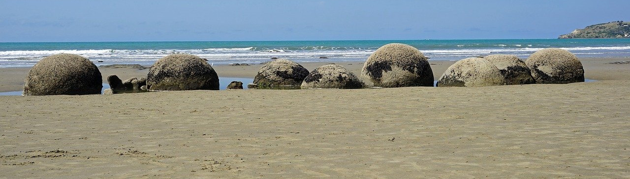 Strand mit runden Felsen, Blick in Richtung Meer
